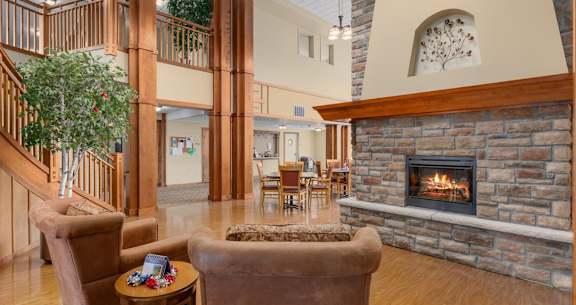 A living room with a fireplace and a staircase.