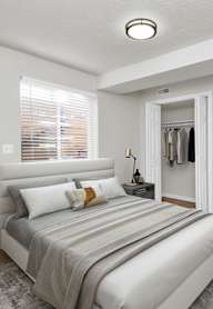 A bedroom with a bed, pillows, and a coat rack.