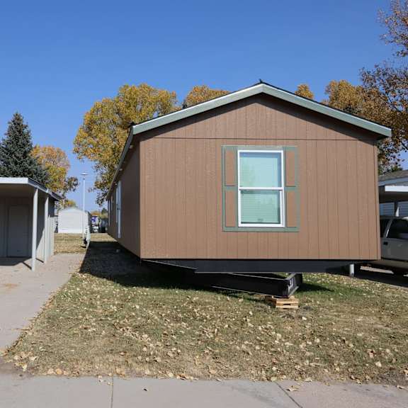 the exterior of a tiny house with a sidewalk in front of it at Mobile Home Village, Cheyenne, Wyoming