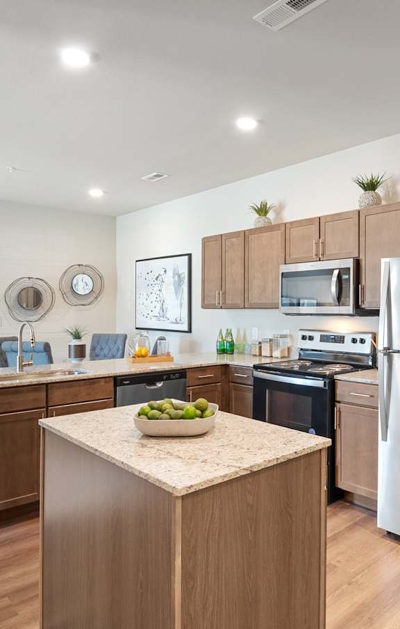 a living room with a large tv and a kitchen in the background  at Aventura at Hawk Ridge, Lake St Louis, 63367