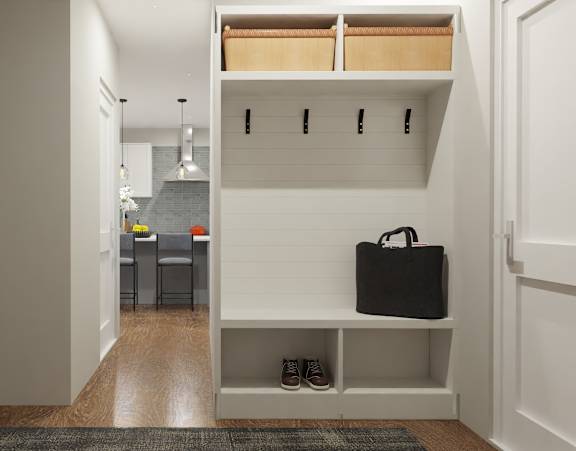 a hallway with white walls and a white closet with shelves and a bag