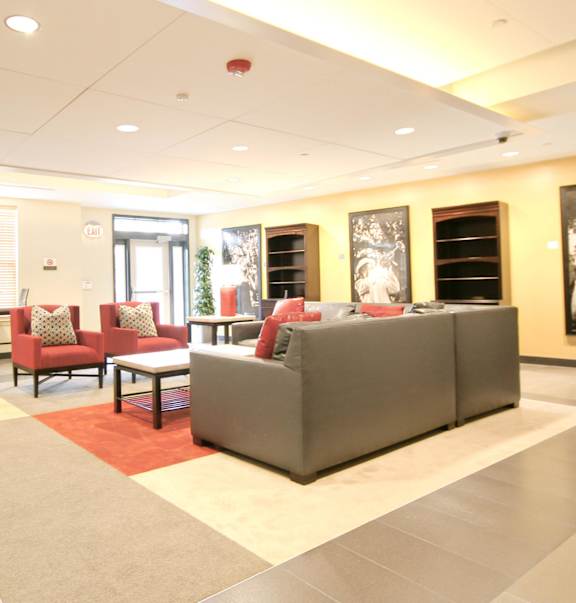 a lobby with chairs and a table and a fireplace