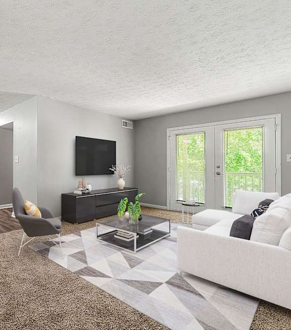 A living room with a white couch, a coffee table, and a television at Bradford Gwinnett Apartments and Townhomes in Norcross, 30071