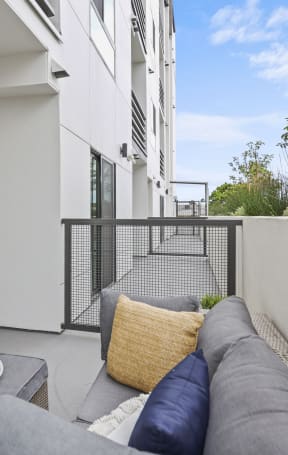two chairs and a couch on a balcony in a 555 waverly unit at The Fairfax Flats Apartments, Los Angeles, CA, 90019