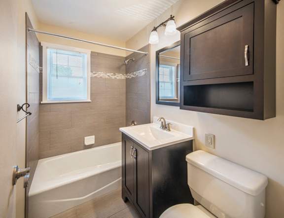 A bathroom with a white tub, sink, and toilet at Rivercrest Apartments, Piscataway , NJ, 08854
