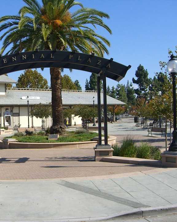 A sign that says Centennial Plaza is in front of a building.