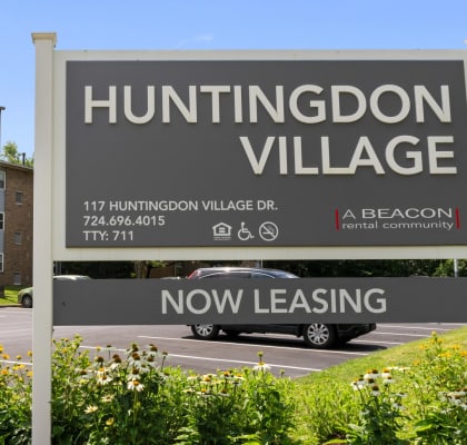 a sign for huntingdon village in front of a building