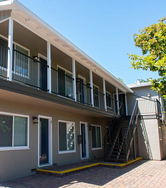 A two-story house with a balcony on the second floor.