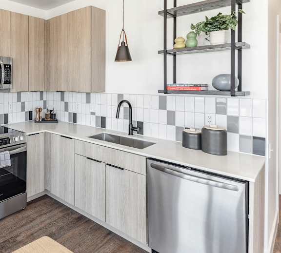 A modern kitchen with stainless steel appliances and wooden cabinets at Anthem House Apartment , Huntsville, AL