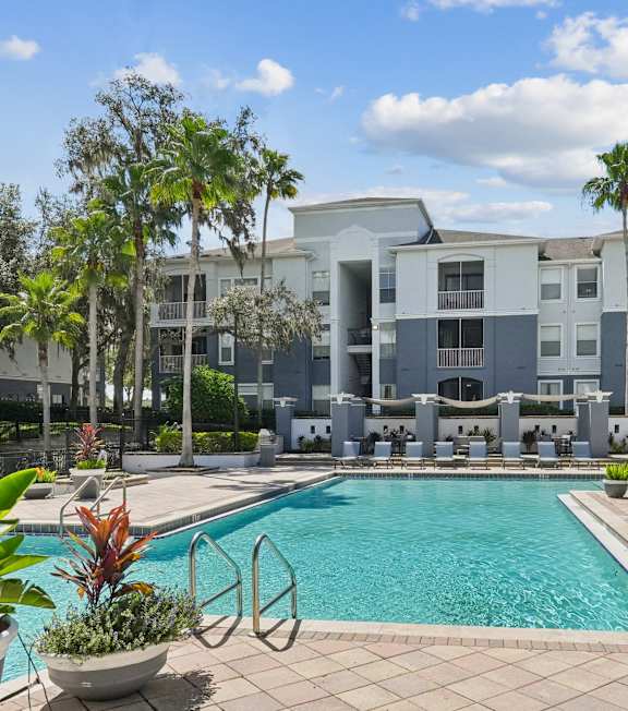 A pool surrounded by lounge chairs and umbrellas.
