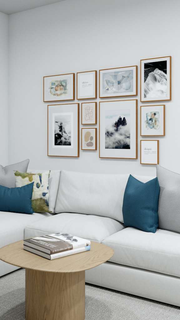 A white couch with blue pillows sits in a room with a coffee table in front of it.