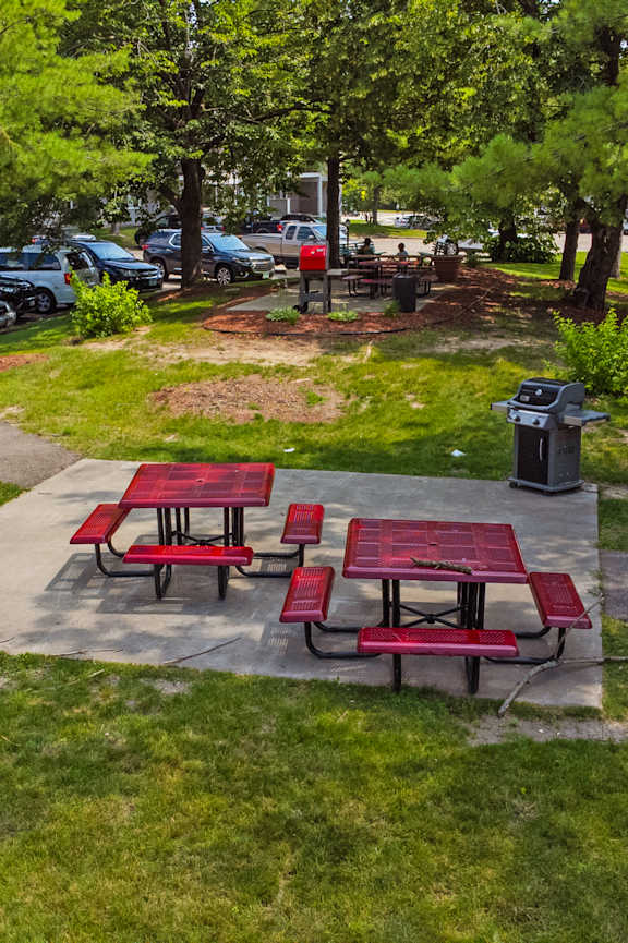 A picnic table with a red tablecloth is surrounded by green grass at Heritage Hills Apartments, Bloomington, MN 55437