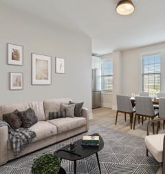 a living room with two couches and a rug and a dining room table