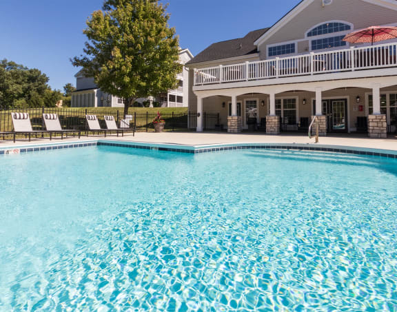 a large swimming pool with a house in the background
