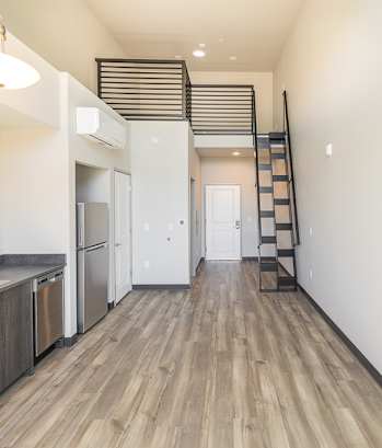 a kitchen with a stainless steel sink and a staircase on the wall