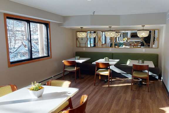 A dining room with a white table and chairs.