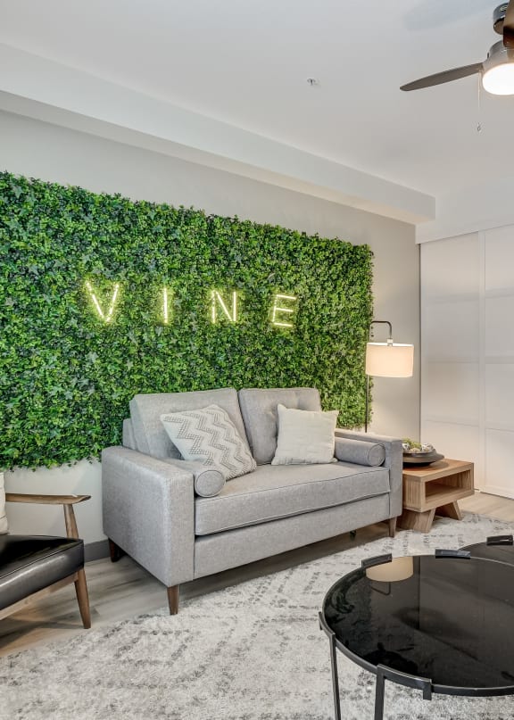 a living room with a green wall with a vine sign on it at The Vine on 8th, Las Vegas, NV, 89101
