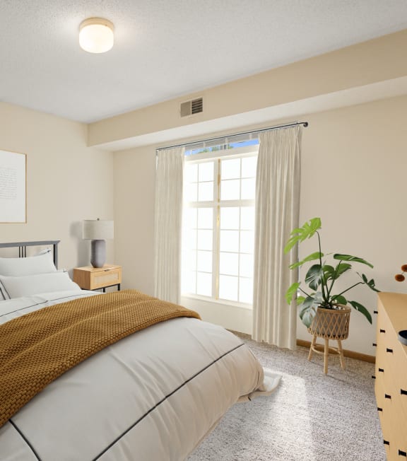 A bedroom with a large bed and a window with curtains.