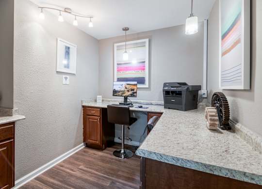 A room with a desk, chair, and a fan.