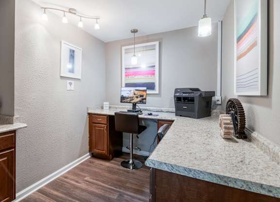 A room with a desk, chair, and a fan.