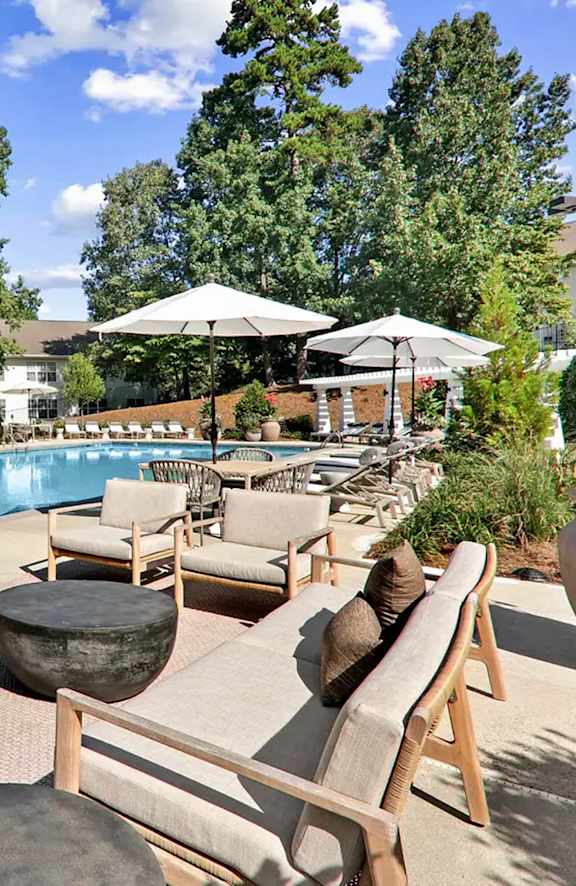 A poolside area with chairs and umbrellas.