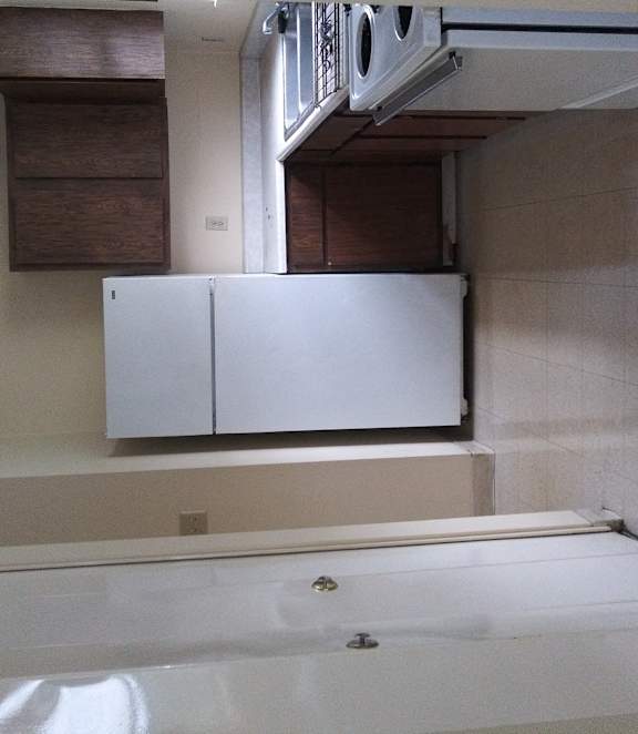 a small bathroom with a tub and a window