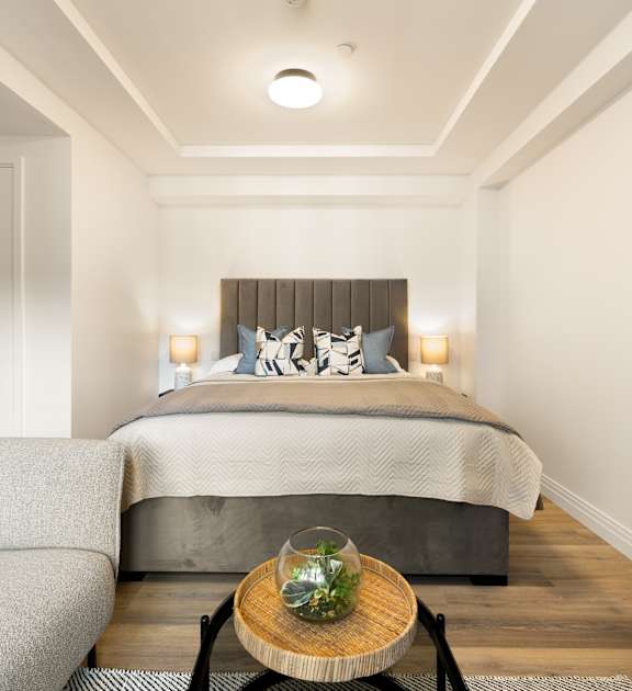 A bedroom with a large bed and a window.