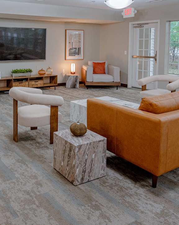 A living room with a grey carpet and a white couch.