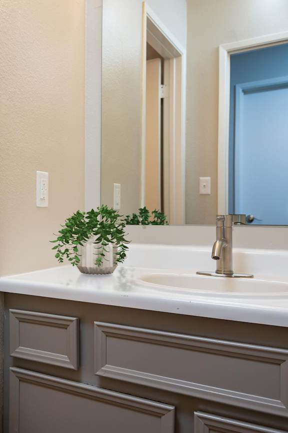 A bathroom with a toilet, sink, and mirror.