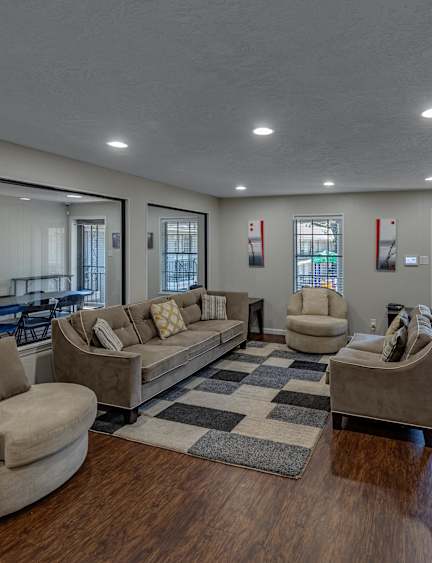 A living room with a white couch, a wooden coffee table, and a TV.