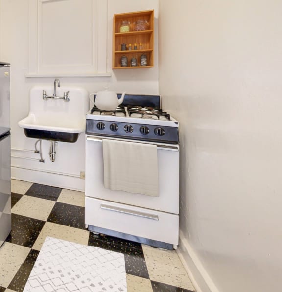 a kitchen with white cabinets and a checkered floor