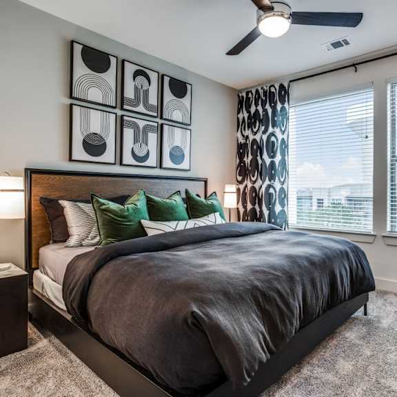 A bedroom with a large bed and a ceiling fan.
