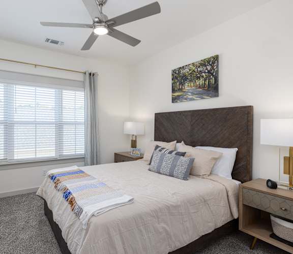 a bedroom with a large bed and a ceiling fan