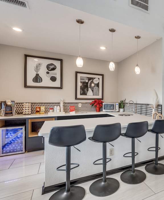 A modern kitchen with a bar area and a television.