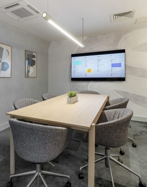 a meeting room with a large screen tv on the wall