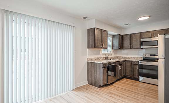 A kitchen with wooden floors and stainless steel appliances.