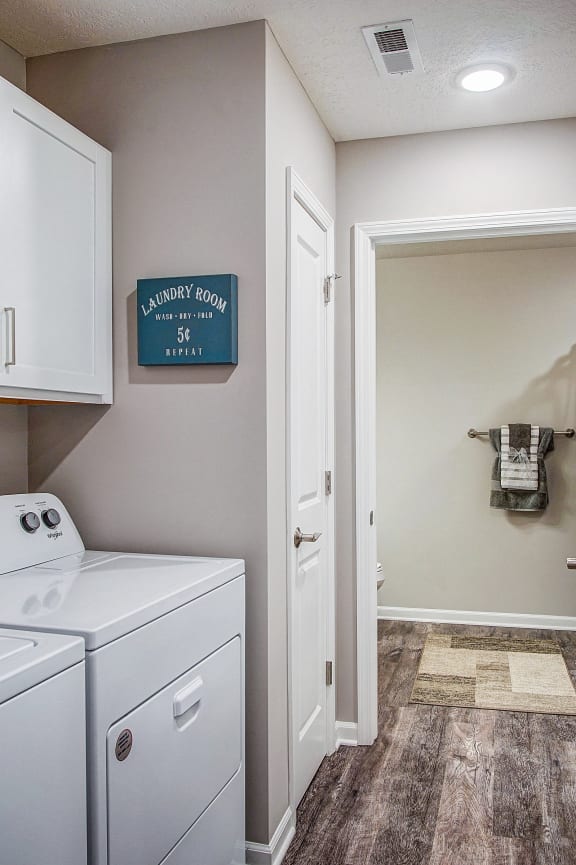 a laundry room with white cabinets and a washer and dryer