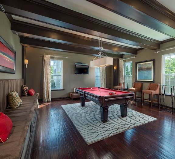 A room with a pool table and a couch.