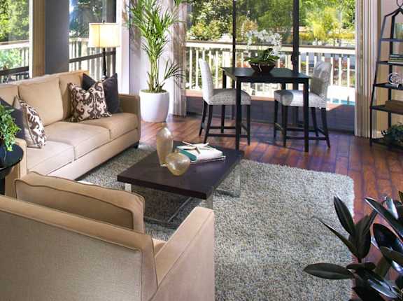 a living room with a couch and a table and a balcony