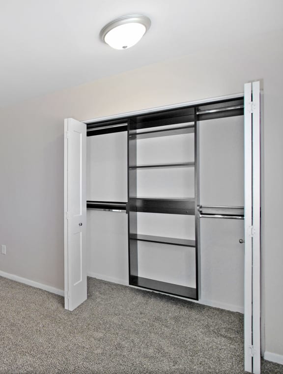 an empty room with white walls and a closet with mirrored doors