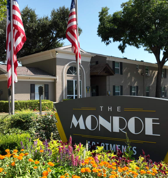 the sign for the apartments flags in front of the building