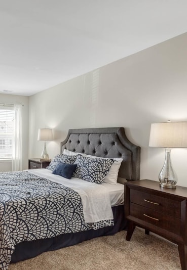 a bedroom with a bed and a dresser and two windows at Mainstreet Village, Michigan