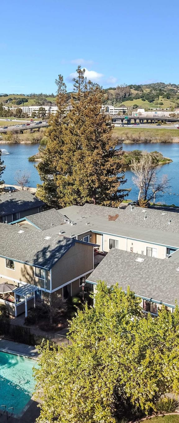 aerial view of apartment buildings, pool, and lake