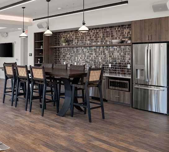 A modern kitchen with dark wood floors and a large island.