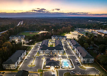 A large resort with a swimming pool and a parking lot.