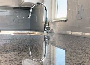 Up close look at the light granite counter tops in the slate finished kitchen at Haven at Uptown in Lincoln, NE