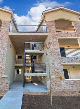 A multi-story apartment building with stone walls and balconies.