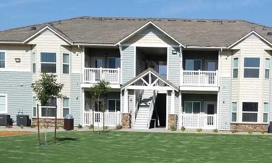 Image of the front of a building, its entry way, and its lawn