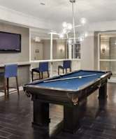 A room with a pool table and a television.