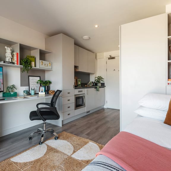 a bedroom with a bed and a desk in a room